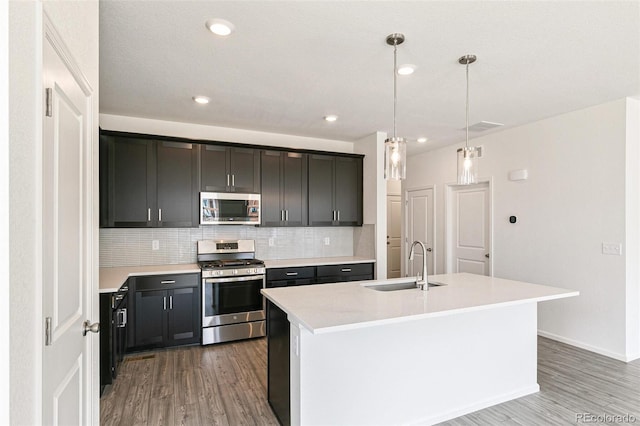 13322 E 110th Way, Commerce City, CO 80022 - kitchen with stainless steel appliances, wood finished floors, backsplash, light countertops, and recessed lighting