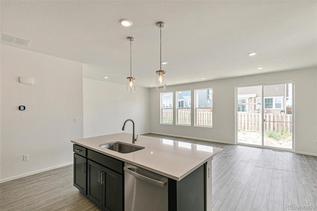 13322 E 110th Way, Commerce City, CO 80022 - kitchen featuring stainless steel dishwasher, light wood-style flooring, light countertops, decorative light fixtures, and open floor plan
