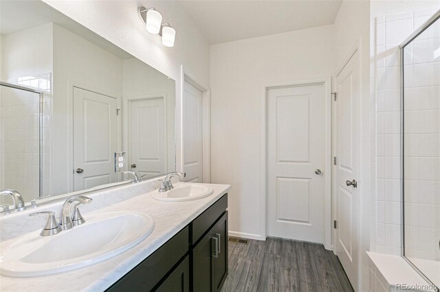 13322 E 110th Way, Commerce City, CO 80022 - full bath with double vanity, wood finished floors, and tiled shower