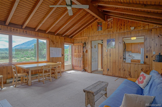 interior space with ceiling fan, a mountain view, wood ceiling, and lofted ceiling with beams