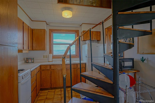 kitchen featuring sink, light tile patterned floors, and white appliances