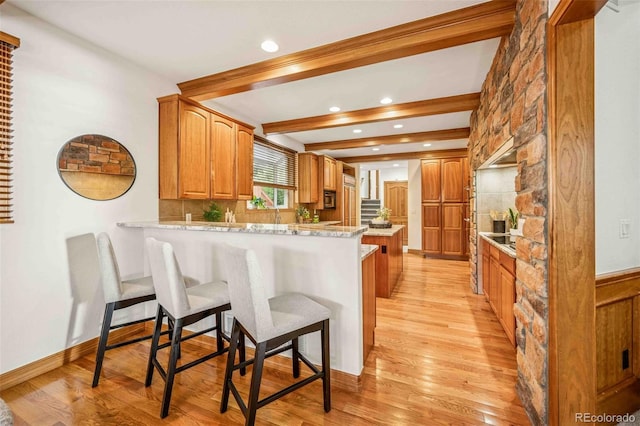 7506 Urban Ct, Arvada, CO 80005 - kitchen with a peninsula, a kitchen bar, light wood-style flooring, recessed lighting, and decorative backsplash