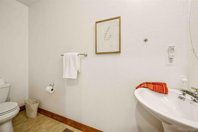 7506 Urban Ct, Arvada, CO 80005 - half bathroom with a sink and wood finished floors