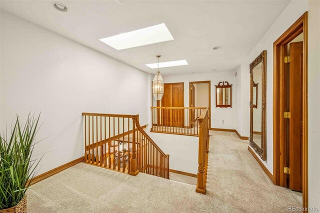 7506 Urban Ct, Arvada, CO 80005 - corridor featuring an upstairs landing, a skylight, carpet, and a chandelier