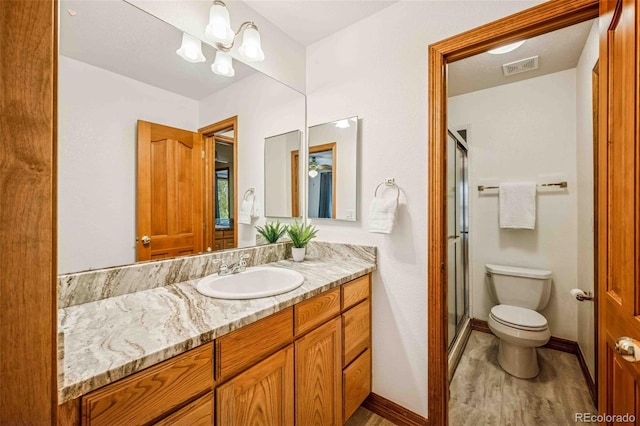 7506 Urban Ct, Arvada, CO 80005 - bathroom featuring vanity, a shower stall, and wood finished floors