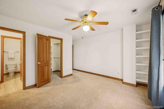 7506 Urban Ct, Arvada, CO 80005 - unfurnished bedroom featuring light colored carpet, a walk in closet, ensuite bathroom, and ceiling fan