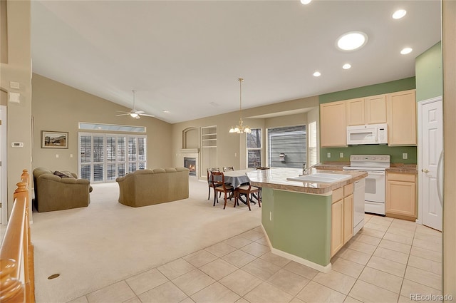 kitchen with white appliances, light tile patterned floors, light colored carpet, open floor plan, and a sink