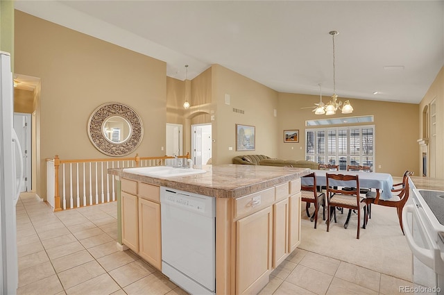 kitchen featuring light tile patterned floors, white dishwasher, a notable chandelier, a sink, and a center island