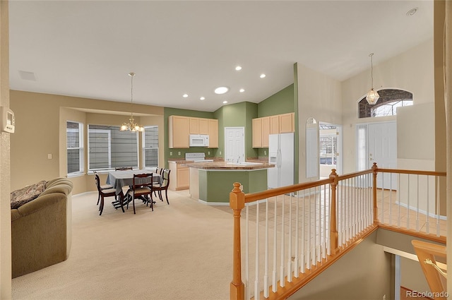 kitchen featuring light carpet, white appliances, a kitchen island, a chandelier, and recessed lighting