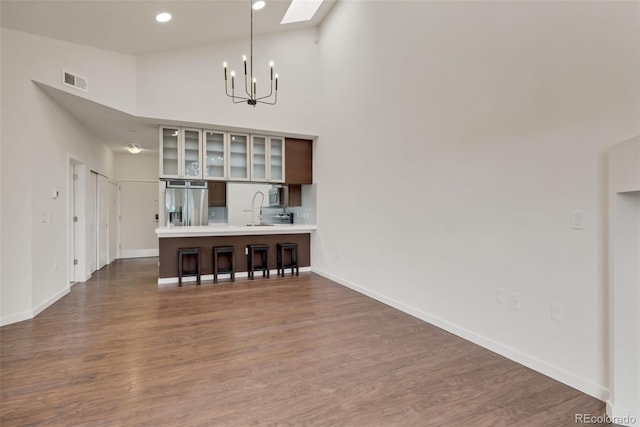 living room featuring a high ceiling, sink, a notable chandelier, and hardwood / wood-style floors