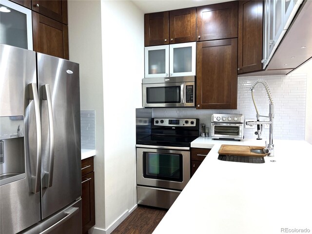 1000 E 1st Ave Unit 405, Denver, CO 80218 - kitchen with light countertops, backsplash, dark brown cabinetry, and stainless steel appliances