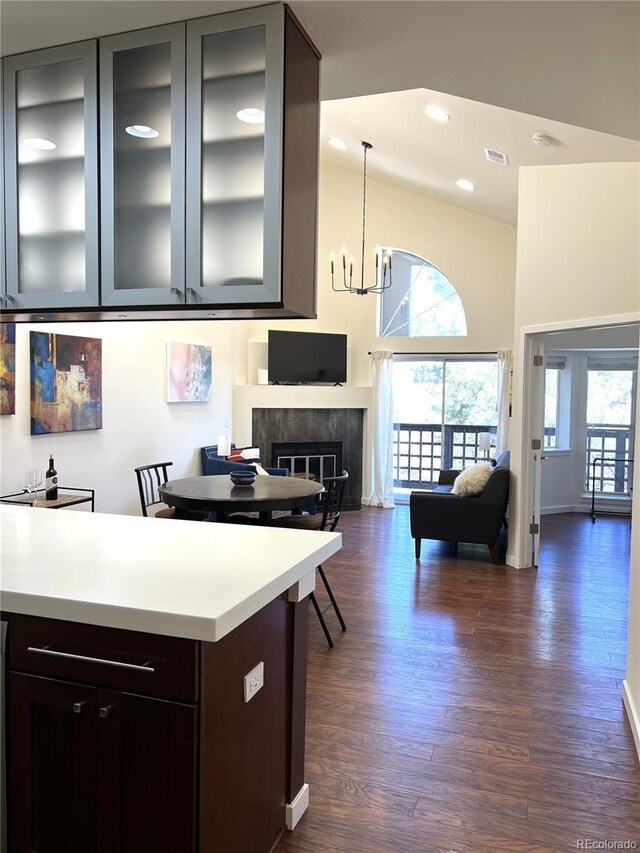 1000 E 1st Ave Unit 405, Denver, CO 80218 - kitchen featuring open floor plan, a high ceiling, dark wood-style floors, light countertops, and a notable chandelier