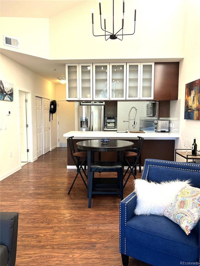 1000 E 1st Ave Unit 405, Denver, CO 80218 - kitchen with visible vents, wood finished floors, a sink, a notable chandelier, and stainless steel appliances