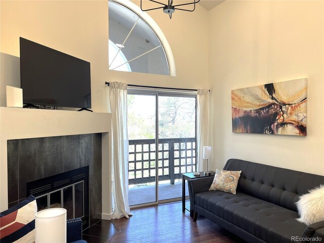 1000 E 1st Ave Unit 405, Denver, CO 80218 - living room featuring a fireplace with flush hearth, wood finished floors, and a towering ceiling