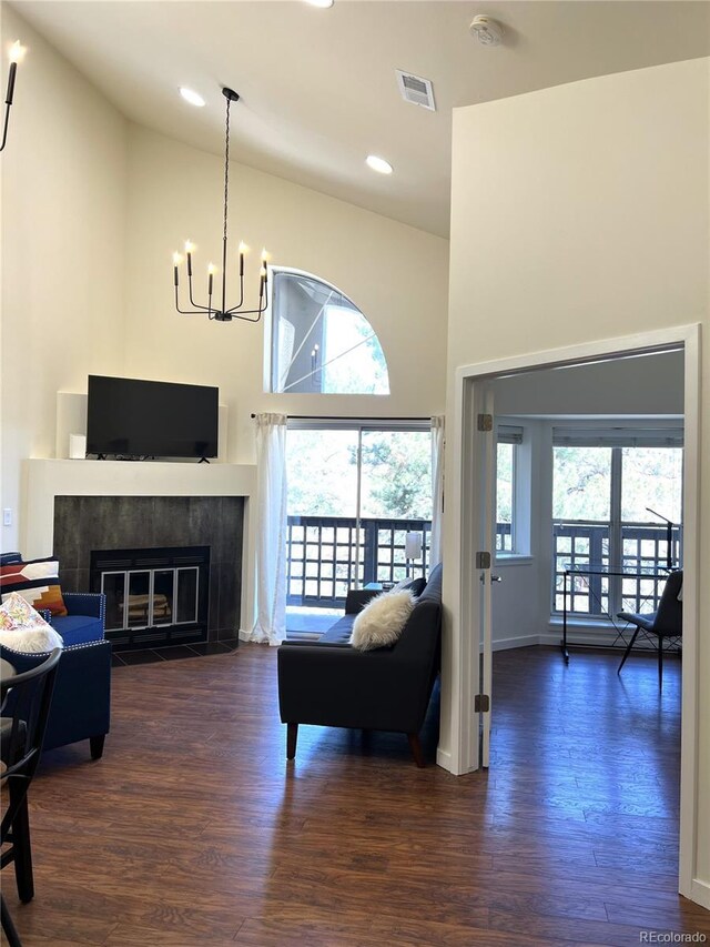1000 E 1st Ave Unit 405, Denver, CO 80218 - living area featuring a high ceiling, a chandelier, a tile fireplace, visible vents, and dark wood-style floors