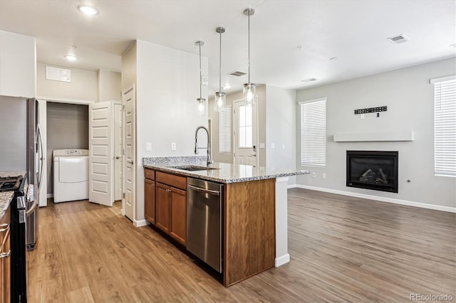 kitchen with sink, light hardwood / wood-style floors, washer / clothes dryer, and appliances with stainless steel finishes