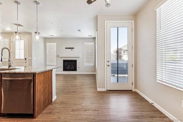 kitchen featuring dark wood-type flooring, a healthy amount of sunlight, and hanging light fixtures