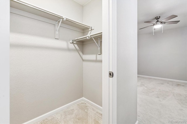 spacious closet featuring light carpet and ceiling fan