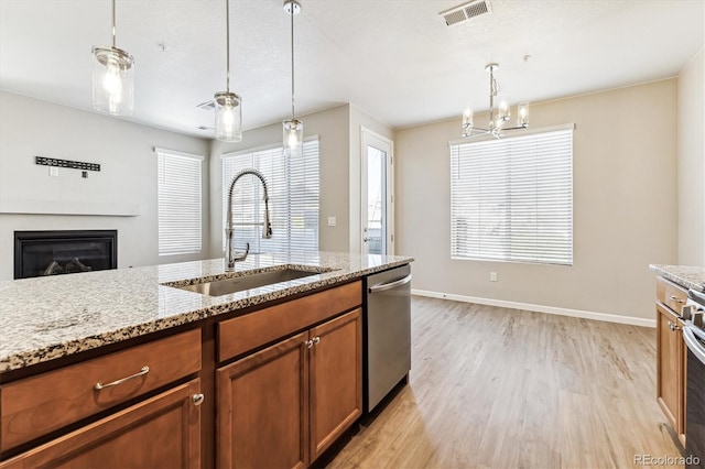 kitchen with sink, appliances with stainless steel finishes, a healthy amount of sunlight, and light hardwood / wood-style floors