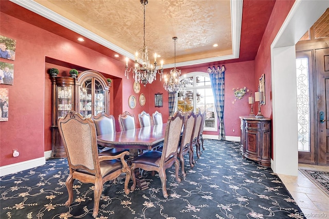 dining area with dark carpet, a tray ceiling, and a notable chandelier