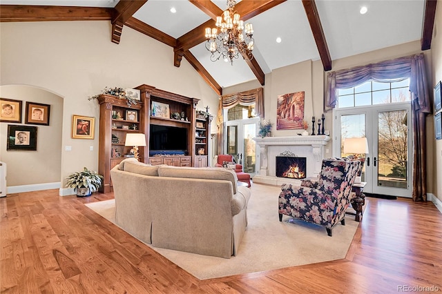 living room featuring a notable chandelier, beam ceiling, light hardwood / wood-style flooring, and high vaulted ceiling