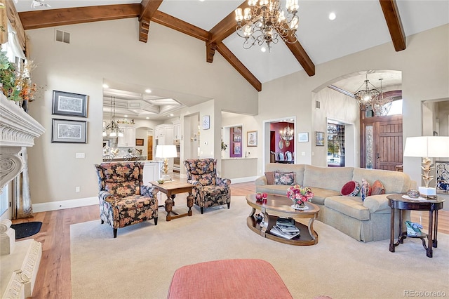 living room featuring a high end fireplace, beamed ceiling, light hardwood / wood-style floors, and high vaulted ceiling