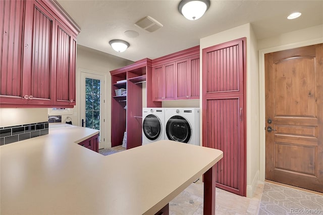 clothes washing area featuring cabinets and washer and clothes dryer