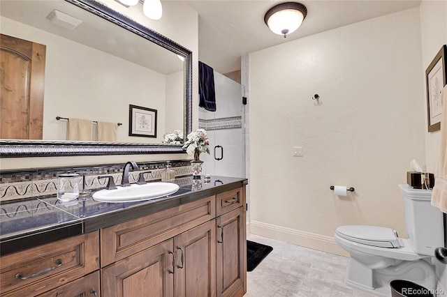 bathroom with tasteful backsplash, vanity, a shower with door, and toilet