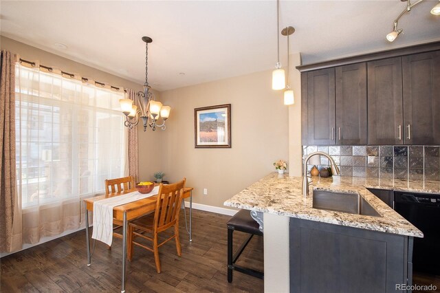 kitchen featuring dark brown cabinetry, sink, decorative light fixtures, and dishwasher