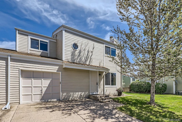 view of property featuring a front yard, an attached garage, driveway, and a chimney