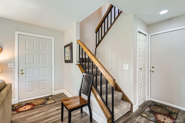 entrance foyer featuring wood finished floors, baseboards, and stairs