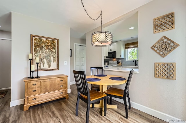 dining area featuring wood finished floors, baseboards, and recessed lighting