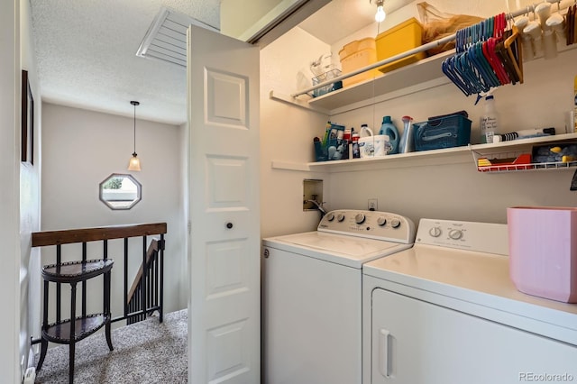 clothes washing area with washing machine and clothes dryer, carpet, and a textured ceiling