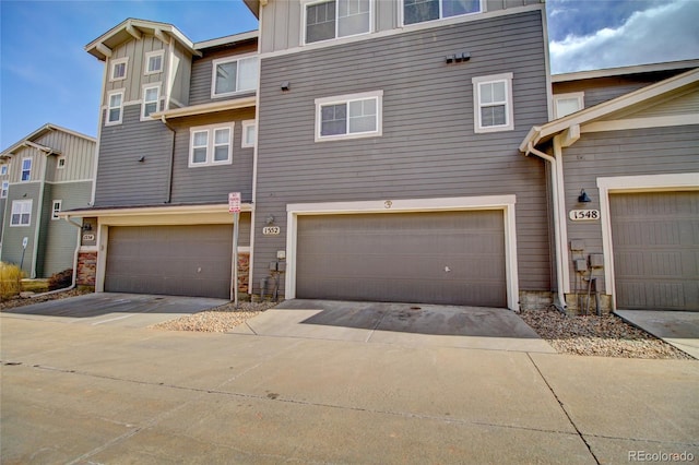 view of property with board and batten siding and concrete driveway