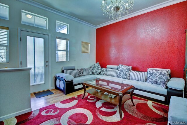 living area featuring ornamental molding, a chandelier, and wood finished floors