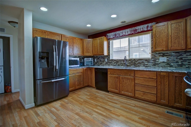 kitchen with visible vents, a sink, refrigerator with ice dispenser, light wood-type flooring, and dishwasher