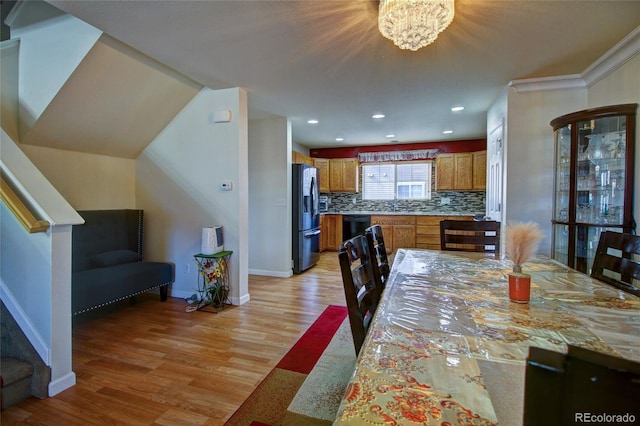 dining space with light wood-style flooring, baseboards, a notable chandelier, and recessed lighting