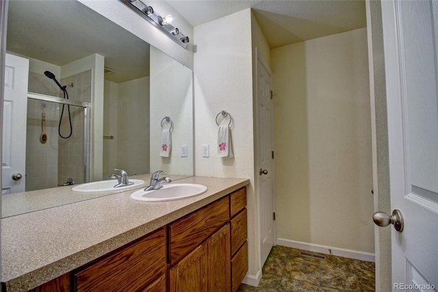 full bathroom featuring baseboards, a tile shower, and vanity