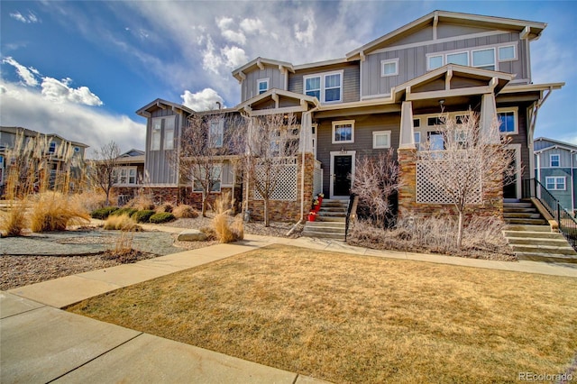 craftsman-style home with a front lawn and board and batten siding