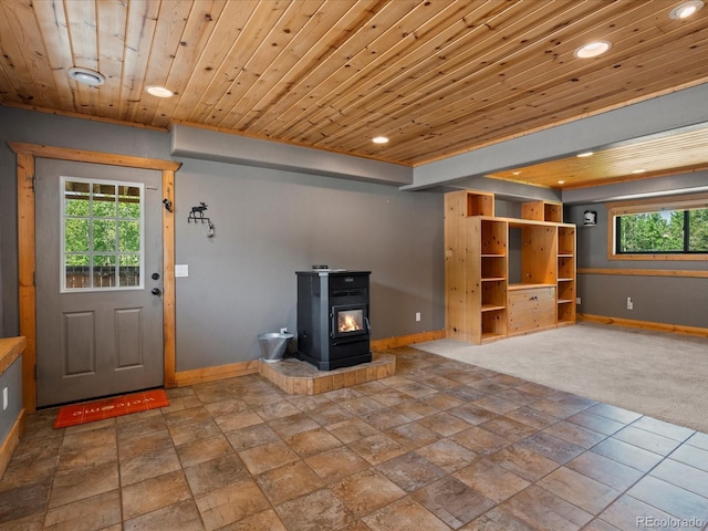 689 S Pine Dr, Bailey, CO 80421 - unfurnished living room with recessed lighting, wood ceiling, stone finish flooring, and a wood stove