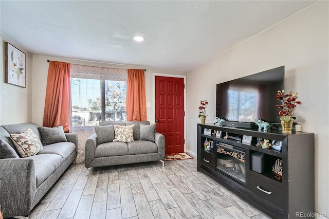 living room featuring light hardwood / wood-style floors and a textured ceiling