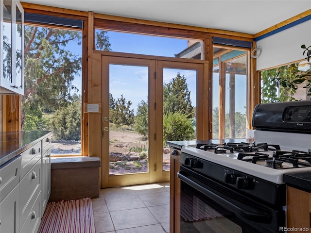 551 Panorama Way, Crestone, CO 81131 - kitchen with gas range, light tile patterned flooring, dark countertops, and healthy amount of natural light