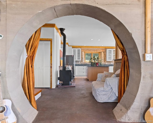 551 Panorama Way, Crestone, CO 81131 - living area featuring a wood stove, arched walkways, and finished concrete flooring