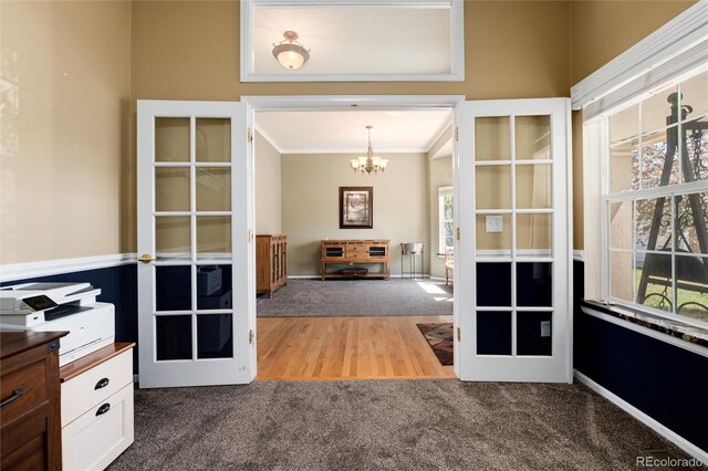unfurnished office featuring carpet floors, a chandelier, ornamental molding, and french doors