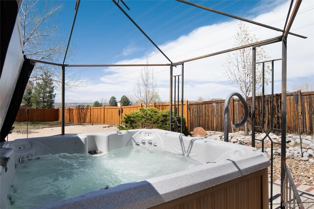 view of patio featuring a hot tub and a fenced backyard