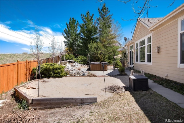 fenced backyard with a hot tub and a patio