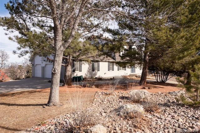 view of property hidden behind natural elements featuring a garage