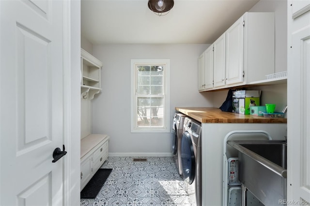 laundry room featuring cabinets, independent washer and dryer, sink, and light tile patterned floors