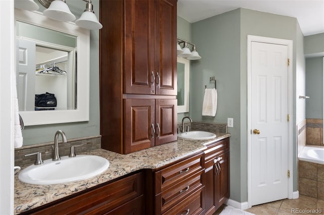 bathroom with tile patterned flooring, vanity, and tiled tub