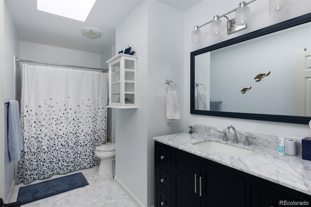 bathroom featuring vanity, a skylight, and toilet